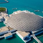 Aerial view of the Louvre Abu Dhabi, showing its distinctive dome and island setting.