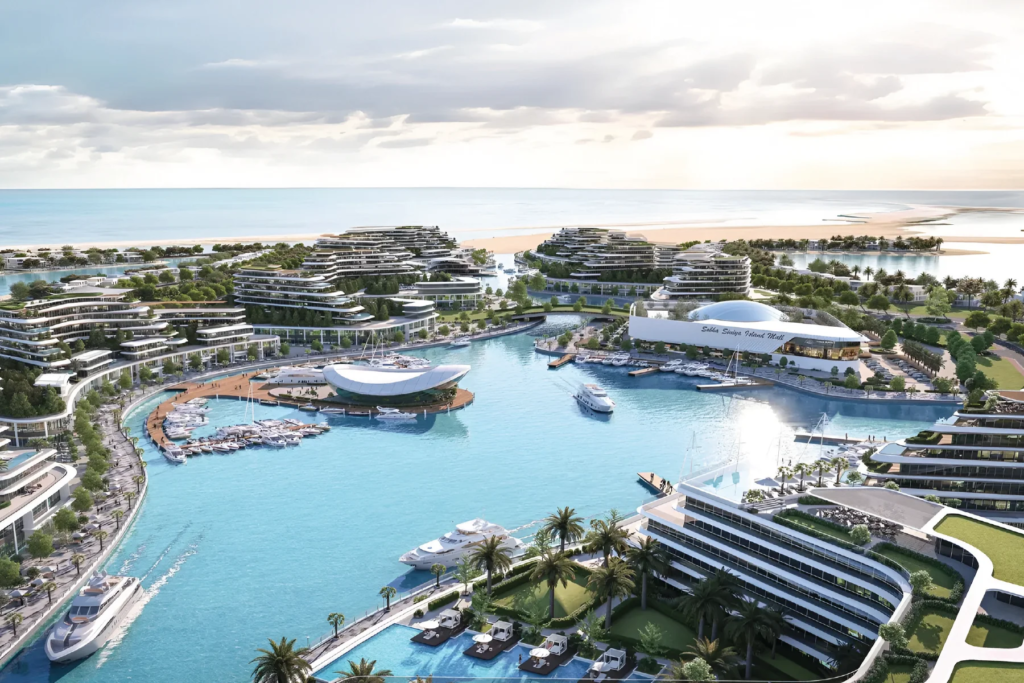 Aerial view of a modern resort with curved buildings, a marina filled with boats, and a sandy beach.